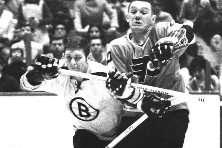 Jimmy Johnson battles for the puck against Boston. An original Flyer in the franchise's first season in 1967-68, he died Tuesday at 78.