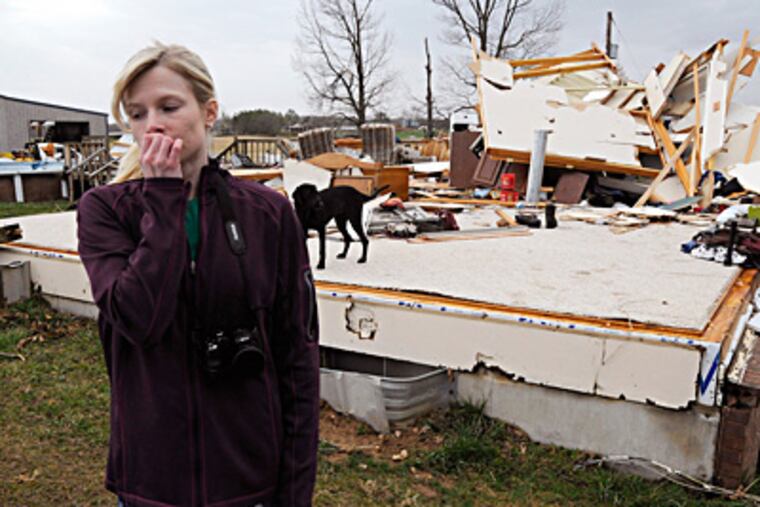 Lindsey Kidd reacts after viewing the rubble of her boyfriend's parents' home outside Puxico, Mo., where one person was reported killed in a storm Wednesday. The country-music mecca of Branson was also hit hard, with 37 injuries reported. (Paul Davis / Associated Press)