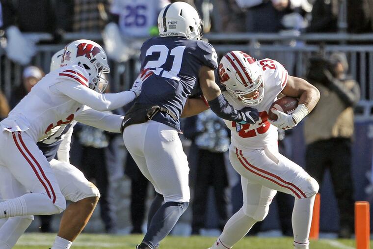 Wisconsin's Jonathan Taylor (23) is pushed out of bounds by Penn State's Amani Oruwariye (21) during the first half of Penn State's 22-10 win on Saturday.