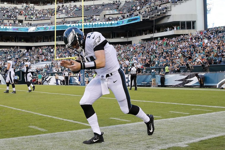 Eagles quarterback Carson Wentz runs back to the Eagles sidelines after throwing a touchdown pass against the Miami Dolphins on Thursday.