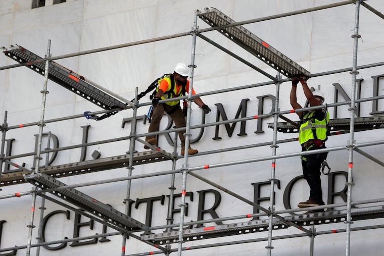 Workers construct scaffolding at the sign for the John F. Kennedy Center for the Performing Arts, Friday, June 12, 2026, in Washington.