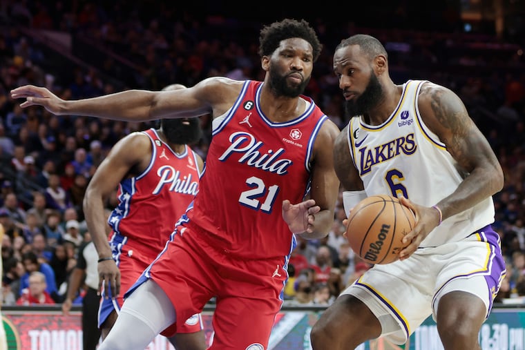 Sixers center Joel Embiid defends as the Lakers' LeBron James drives in the first quarter of a game in December 2022. Could the two stars soon be teammates?