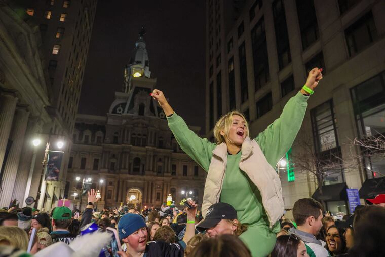 Gianna Bowen, of Bucks County, on the shoulders of her friend Thomas Connley, of Bucks County, celebrating along South Broad Street when the Eagles won the conference championship.