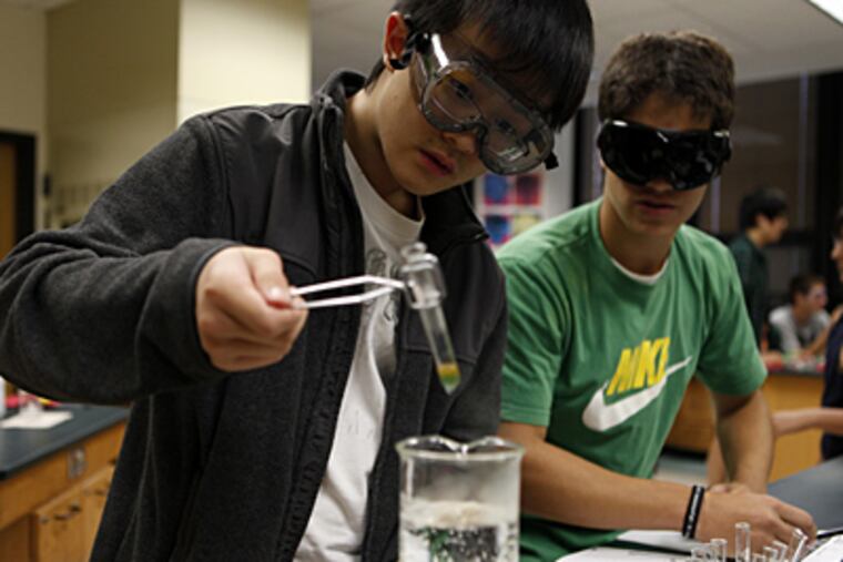 Sophomores Eric Chang, 15, left, and Spencer Michelson, 15, perform a column chromatography separation of grape Kool Aid lab during a Chemistry PCB, Level 4 summer school class at New Trier Township High School in Winnetka, Ill. (Michael Tercha/Chicago Tribune/MCT)