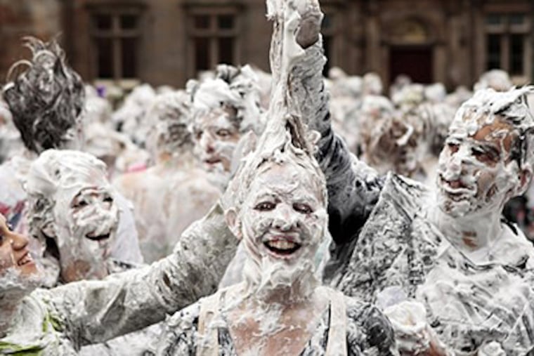 First-year students at St Andrews University take part in a foam fight in St. Salvator's Quad, St. Andrews, Scotland as part of the Raisin Day celebrations. Raisin Weekend is a tradition "rite of passage" for new students. (AP Photo/David Cheskin/PA Wire)