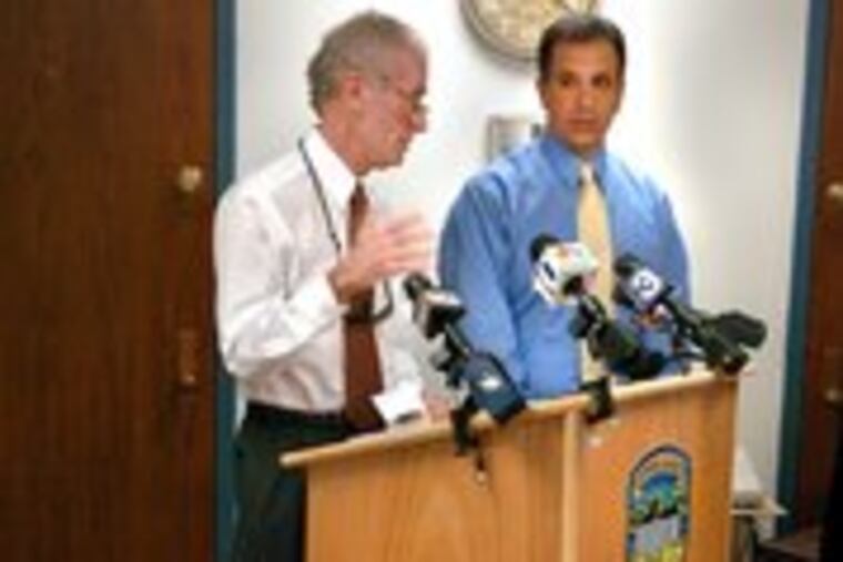 Weapons confiscated by Upper Darby police were displayed in October by Police Chief Michael Chitwood (left) and Sgt. Larry Santucci. Under Chitwood, guns are now melted down.