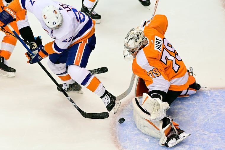 Flyers goaltender Carter Hart makes a save against New York Islanders left winger Anders Lee during an Eastern Conference playoff game in Toronto on Sept. 5.