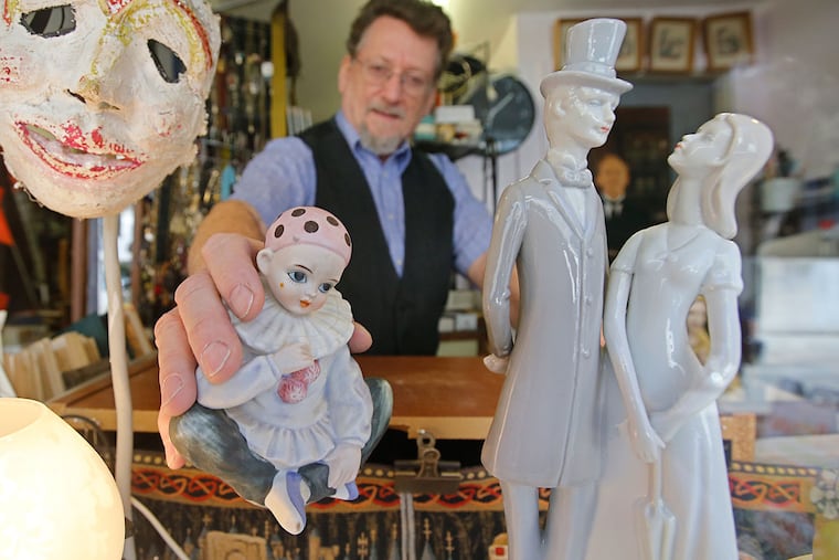 Michael Mancuso places a ceramic clown in the front window of his shop, Circa Gallery, an eclectic junk store that has endured through four decades of change on Sansom Street.