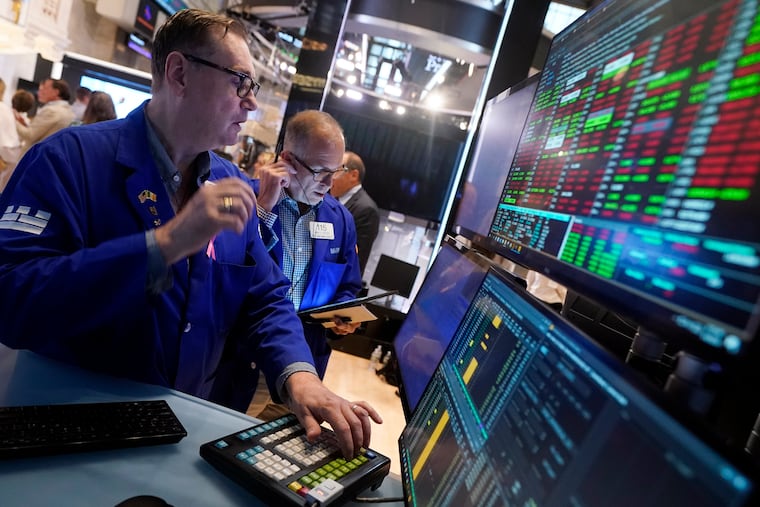 Specialist Patrick King, left, works at his post on the floor of the New York Stock Exchange on Tuesday, Aug. 6, 2024.