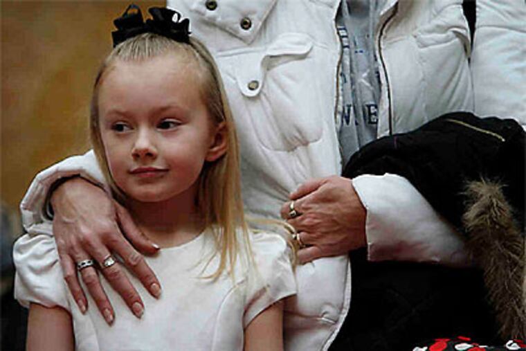 Cassidy Komar, 7, of Havertown, was one of hundreds of children who waited with their parents to take a turn on Santa's knee. (Laurence Kesterson / Staff Photographer)