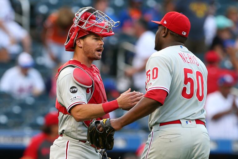 Phillies closer Hector Neris shakes hands with catcher Andrew Knapp Sunday after closing out the Phillies' 10-7 win over the New York Mets at Citi Field.