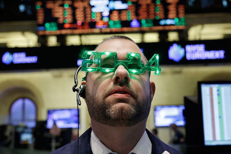 A trader wears glasses celebrating the new year while working on the floor at the New York Stock Exchange in New York, Tuesday, Dec. 31, 2013. (AP Photo/Seth Wenig)