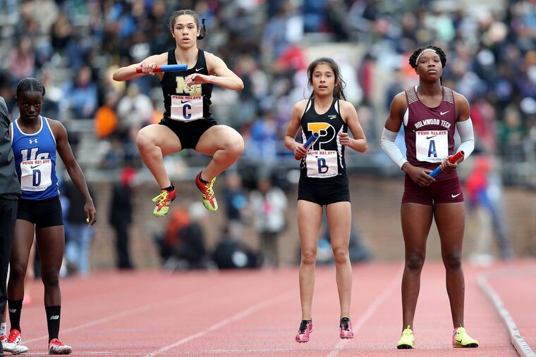 Neumann-Goretti’s Kami Joi Hickson (second from left) warms up before the start of the high school girls’ 4×800 Championship of America race. The Saints finished second.
