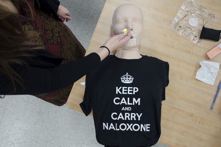 Harm Reduction Coordinator Allison Herens administers naloxone nasal spray to a test dummy.