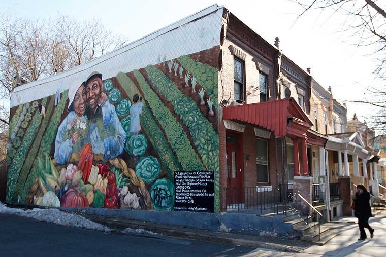 At 44th and Market a row house sports a mural of an elder couple and their city vegetable garden. " ( MICHAEL BRYANT / Staff Photographer )