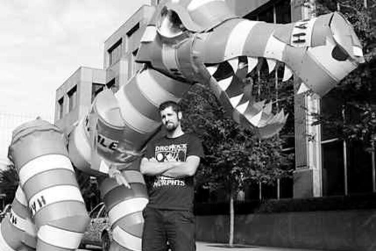 Joseph Carnevale with his second "Barrel Monster," made from highway barrels. He earned Internet fame - but also a police citation - for an earlier version made of filched barrels.