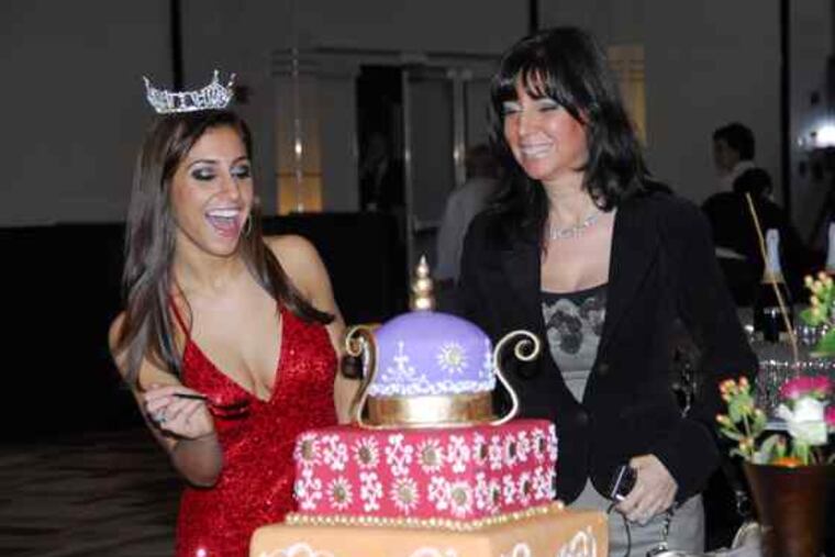 Miss Keystone Andrea Helfrich pokes another crownedcontestant - a wedding cake in an annualcompetition raising money for the City of Hope cancer center. With Helfrich, who will vie to be the next Miss Pennsylvania, is her mother, Susan. The benefit was Tuesday at the Loews Hotel.