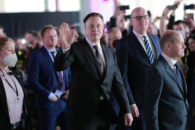 German Chancellor Olaf Scholz (right), Brandenburg State Premier Dietmar Woidke (second from the right) and Tesla CEO Elon Musk (center) attend the official opening of the new Tesla electric car manufacturing plant on March 22, 2022, near Gruenheide, Germany.