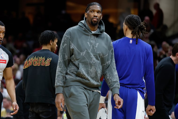 Injured Sixers center Joel Embiid stands during a timeout in the second half of the team's NBA basketball game against the Cleveland Cavaliers, Friday, March 29, 2024, in Cleveland.