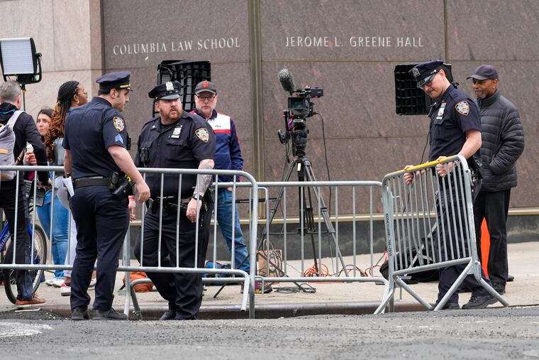 New York City Police officers set up barricades around gathered members of the press outside the Columbia University campus.