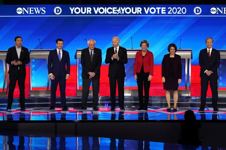 From left, Democratic presidential candidates Andrew Yang, former South Bend, Ind., Mayor Pete Buttigieg, Sen. Bernie Sanders (I-Vt.), former Vice President Joe Biden, Sen. Elizabeth Warren (D-Mass.), Sen. Amy Klobuchar (D-Minn.), and Tom Steyer stand on stage at the start of the Democratic presidential primary debate in the Sullivan Arena at St. Anselm College in Manchester, N.H., on Friday, Feb. 7, 2020.