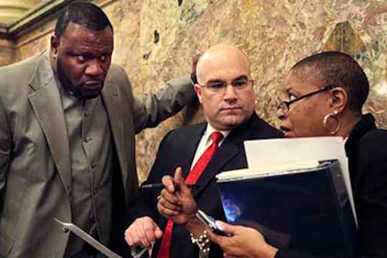 Majority Floor Leader Rep. Todd Eachus, D-Luzerna, center, and Rep. Jake Wheatley, D-Allegheny, left, talk with an unidentified staff member on the floor in the House in this Oct. 2009 file photo. (AP File Photo)