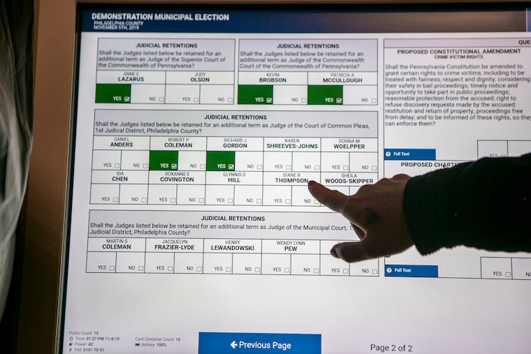 A Philadelphia election worker shows a voter how to use the new voting machines.