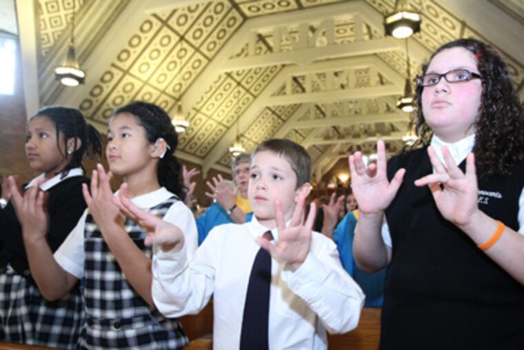 At a Mass celebrating Archbishop Ryan Academy for the Deaf's 100 years, students (From left) Natalya Gilmore, Sophie Roberto, Michael Greco, and Nishma Reyes sign. (Charles Fox / Staff Photographer)