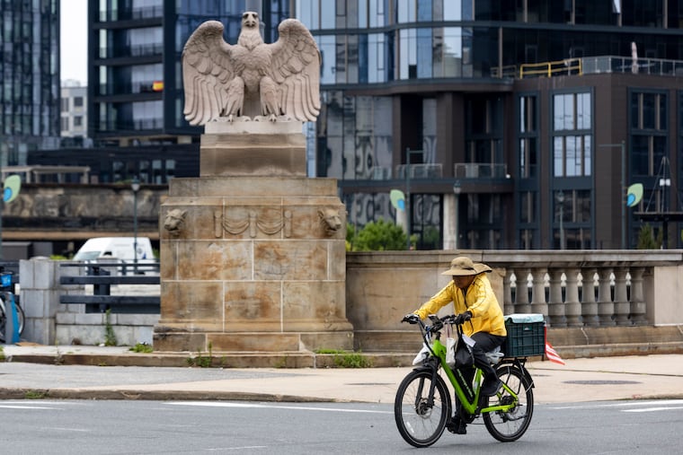 A delivery driver riding an e-bike drives past an intersection on Walnut Street in Philadelphia on Tuesday, July 7, 2026.