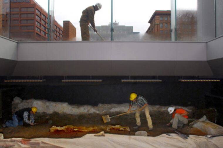 Archaeologists (from left) Jed Levin, Matthew Harris, and Tod Benedict uncover the excavated Presidentâs House foundation, which had been protected during construction. George Benigno, a mason, cleans over them at ground level. (Tom Gralish / Staff Photographer)