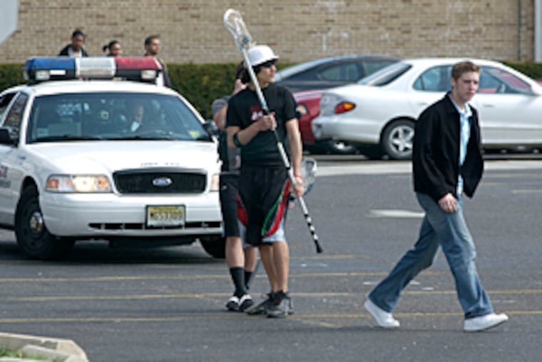 Police keep watch as students leave Winslow Township High School on April 5, 2006, after authorities announced they had broken up an alleged massacre plot at the school.