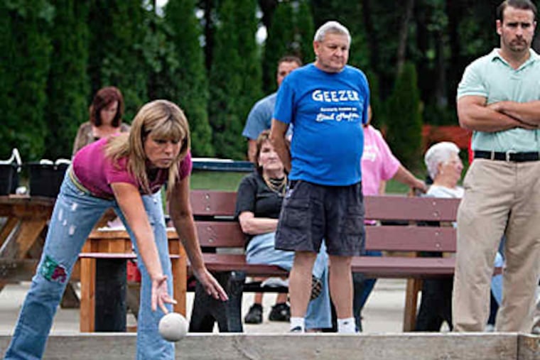 At the Conshohocken Boccista Club court, Judy Greco, 50, throws in a match with Wayne Goshen (center), 71, and Adam Moore, 33. At one time, the region was studded with all-male leagues. (David M Warren/Staff)