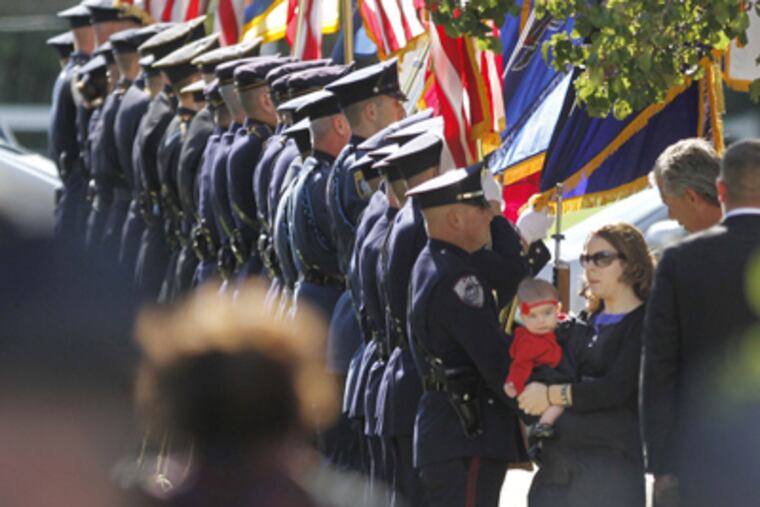 Lynsay Fox holds daughter Kadence as they pass the honor guard. (MICHAEL BRYANT / Staff Photographer)
