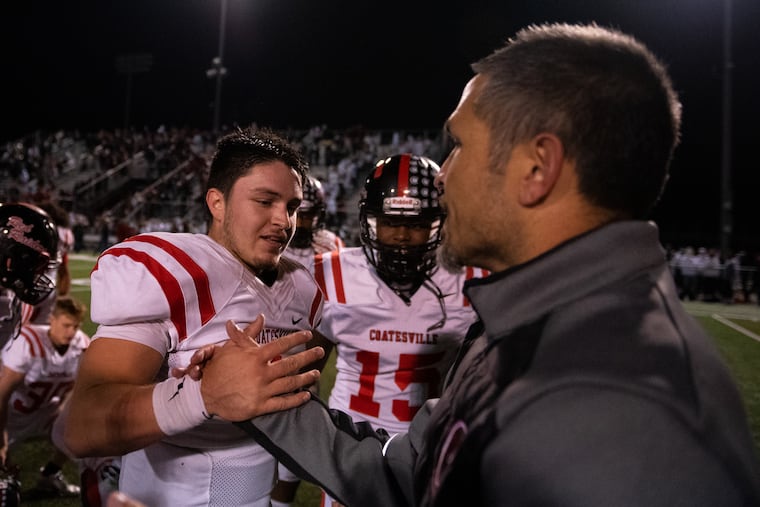 Coatesville quarterback Ricky Ortega celebrates with his father and head coach, Matt Ortega, following a win over Downingtown West on Oct. 18.