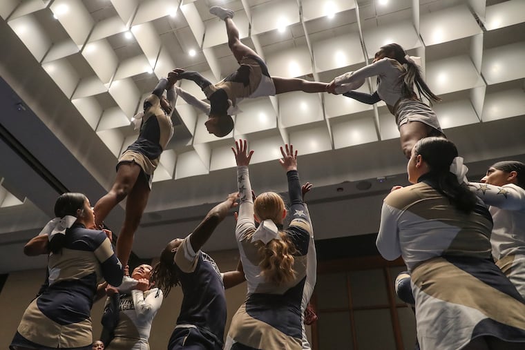 Members of the George Washington High School cheer team practice on the first day of competition at the Kay Bailey Hutchison Convention Center in Dallas. The team became the first Philadelphia School District cheerleaders to qualify for nationals.