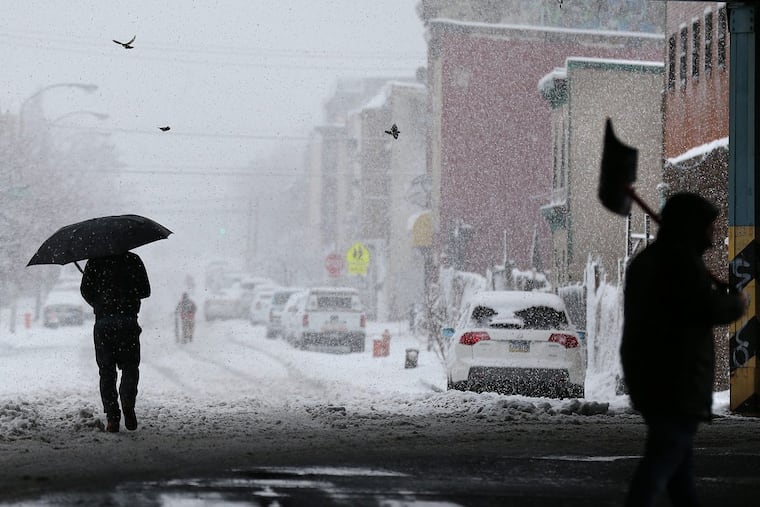 Pedestrians navigating Front Street at Kensington Avenue during the March 7 snowstorm.