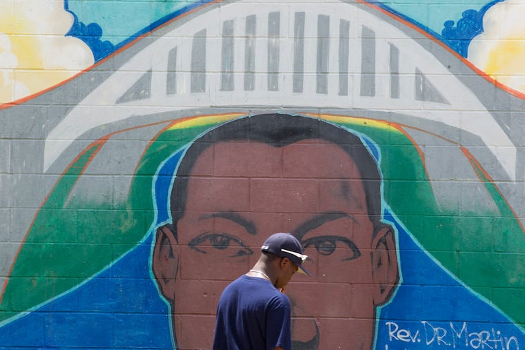 Jahli Hendricks, of the South Philadelphia-based Anderson Monarchs youth baseball team, pauses by a mural featuring the Rev. Dr. Martin Luther King Jr. at Civil Rights Memorial Park at the base of the Edmund Pettus Bridge in Selma, Ala., in June 2015. The bridge was the site of violence at the start of the march for voting rights that went from Selma to Montgomery.
