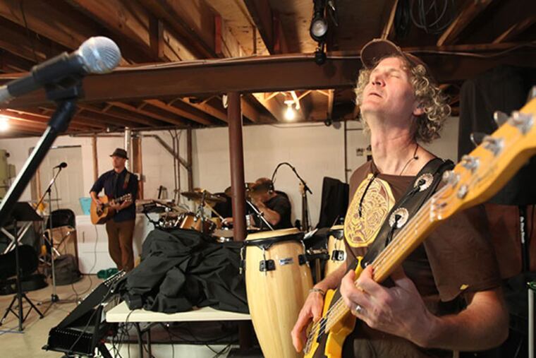Bass player John McLeod, right, is really into the music as the band, "The Wayside Shakeup", rehearse in drummer's Mike Leger's basement. Meet "The Wayside Shakeup," a five-member rock band with roots in Haddon Township, NJ. They're starting to get some attention and are looking forward to what they hope will be a breakthrough show at the Troc on September 20, 2013. ( MICHAEL BRYANT / Staff Photographer )