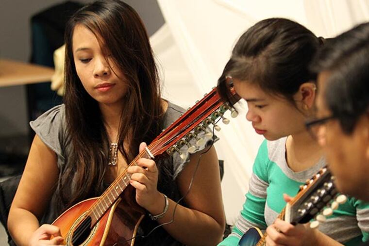 Vicky Faye Aquino (left) and Brigitte Weesner of The Philippine Folk Arts Society rehearse traditional Philippine folk music with their banduria instrument at the Asian Arts Initiative in Chinatown on Monday, December 2, 2013. Local Filipino groups are lobbying the White House, Congress and U.S. Immigration officials to get the administration to grant "temporary protected status" to Filipinos in America at the moment. ( Yong Kim / Staff Photographer )
