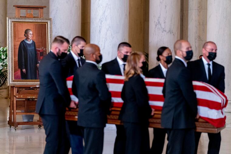 The flag-draped casket of Justice Ruth Bader Ginsburg, carried by Supreme Court police officers, arrives in the Great Hall at the Supreme Court in Washington, Wednesday, Sept. 23, 2020. Ginsburg, 87, died of cancer on Sept. 18.