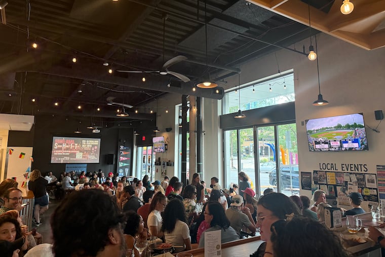 Fans gather at Two Locals to watch the first-ever Women's Pro Baseball League game on Saturday.