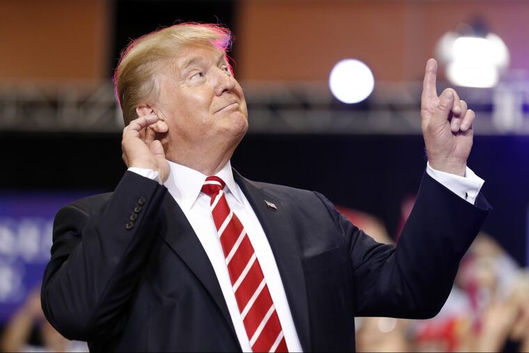 President Donald Trump reacts to the song as he arrives at a rally at the Phoenix Convention Center on Tuesday.