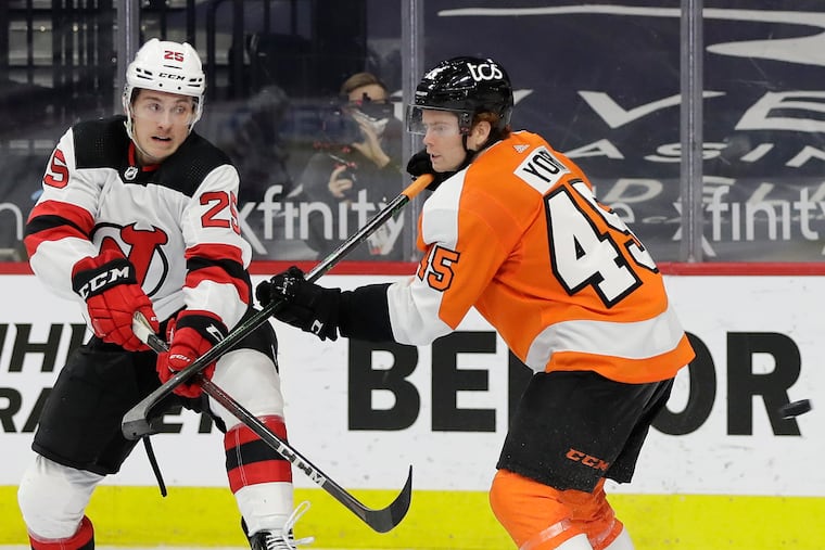 Flyers defenseman Cam York (right) defending New Jersey Devils left winger Nolan Foote during the season finale on May 10. York is one of the Flyers' blue-chip prospects.