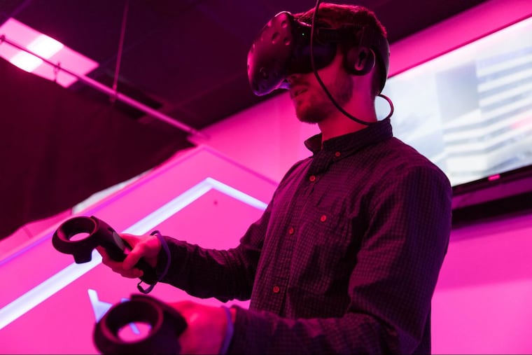 Curtis Baillie, an employee at Liberty Virtual Reality and senior at Rowan University, plays a virtual reality game where he's flying at the virtual reality arcade at Rowan University in Glassboro, NJ on Friday, March 30, 2018.