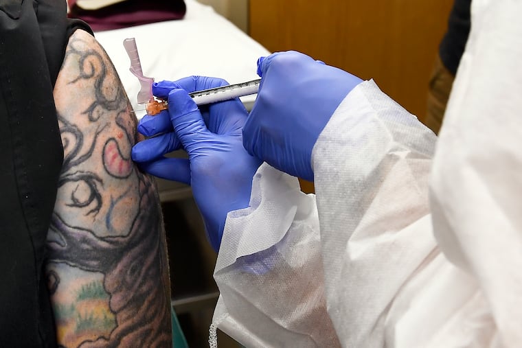 Nurse Kathe Olmstead gives volunteer Melissa Harting, of Harpersville, N.Y., an injection of a possible COVID-19 vaccine, developed by the National Institutes of Health and Moderna Inc., in Binghamton, N.Y., in July.