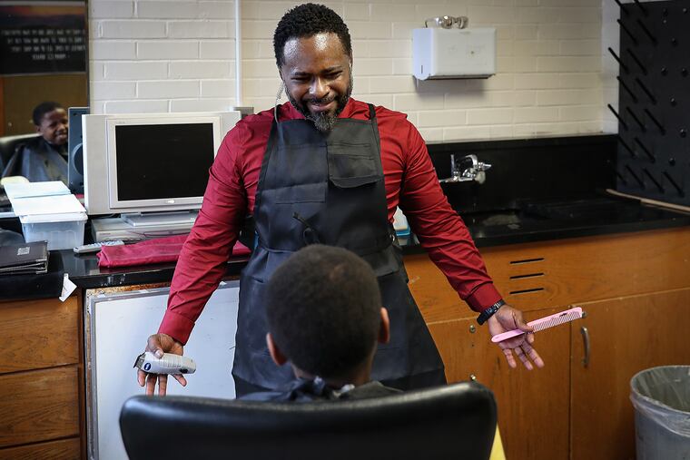 Principal Terrance Newton talks with student Michael Harley, 8, while giving him a haircut at Warner Elementary in Wilmington on Jan. 14, 2020.