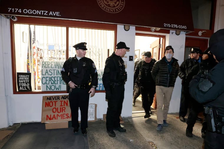 Police take into custody individuals who were involved in a sit-in demonstration at Rep. Dwight Evans office on Ogontz Avenue in Philadelphia Friday.