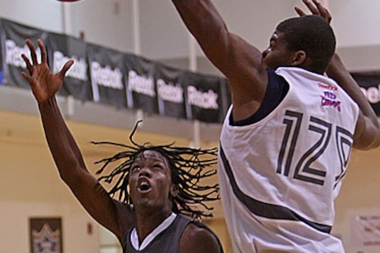 Tyrone Garland, left, works around Keith Coleman, right, to score during their game Thursday afternoon at Philadelphia University. (Michael Bryant / Staff Photographer)