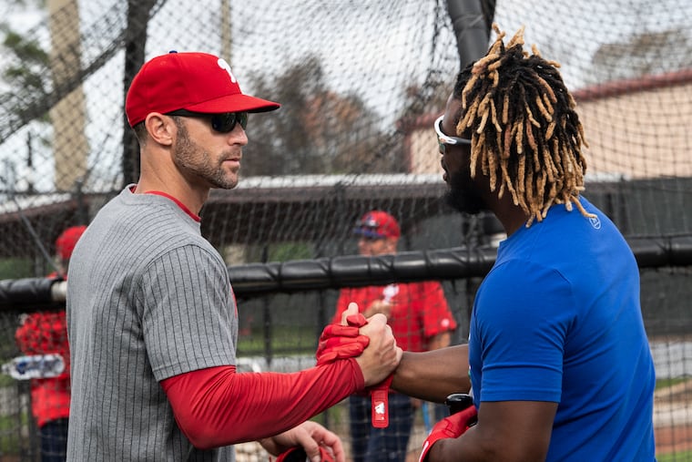 Odubel Herrera (right) shakes hands with manager Gabe Kapler during spring training.