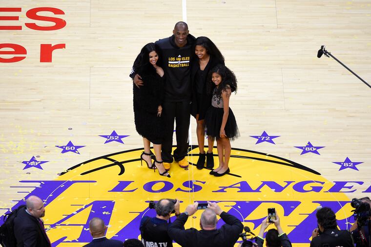 Los Angeles Lakers' Kobe Bryant poses for pictures with his wife Vanessa, left, and daughters Natalia, second from right, and Gianna as they stand on the court after an NBA basketball game against the Utah Jazz, in Los Angeles in 2016.